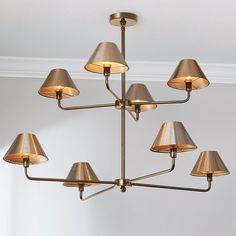 a chandelier with six lamps hanging from it's sides in a room