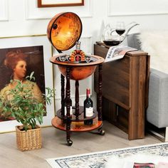 a table with a wine glass and bottle on it in front of a couch next to a potted plant