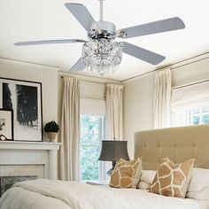 a bedroom with a large bed and a ceiling fan in the middle of the room