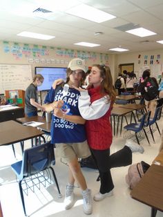 two people hugging each other in a classroom