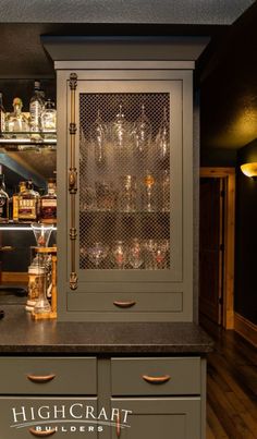 the bar has many bottles and glasses on it's glass doors, along with an old fashioned liquor dispenser