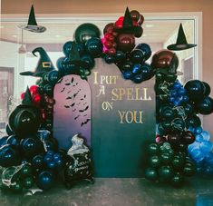 there is a sign that says put a spell on you surrounded by balloons and witch hats