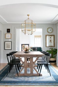 a dining room table with four chairs and a chandelier hanging from the ceiling