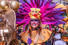 a woman in an elaborately decorated headdress and costume at a carnival parade