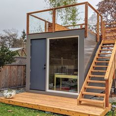 a small house with stairs leading up to the door and windows on top of it