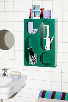 a bathroom with a green shelf holding toothbrushes, combs and other items