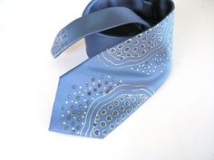 I painted this extravagant men necktie in abstract design inspired by necklace made before. This light blue dotted necktie painted using free hand drawing with gutta to create interesting and exclusive look. I used a silver and gold colors to create special effects and make it modestly shining and perfect looking for special occasions in your life:) Perfect gift for men, who loves artistic style. ➽ Color elegant pale blue All items are unique in color combination and design. ➽ Size 3 1/4" x 57" Tied Hands, Free Hand Drawing, Personalized Gifts For Men, Tie Accessories, Bib Necklace, Gift For Men, Necktie, Blue Man, Neck Tie