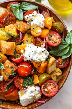 a bowl filled with tomatoes, mozzarella and basil