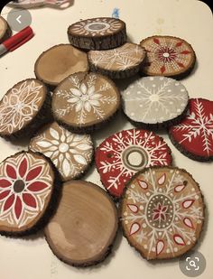 several wooden slices with designs on them sitting on a table next to paintbrushes