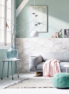 a living room filled with furniture next to a white table and wall covered in pictures