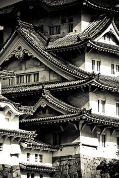 black and white photograph of an old building with roof tiles on it's sides