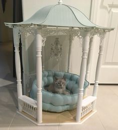 a cat is sitting in a bed that looks like a gazebo for the cats