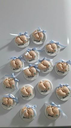 there are many small cookies with baby feet on them and blue ribbon around the top