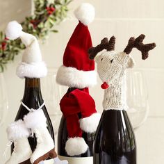 two wine bottles decorated with santa hats and reindeer noses