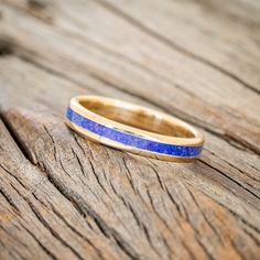 a blue ring sitting on top of a wooden table next to a piece of wood