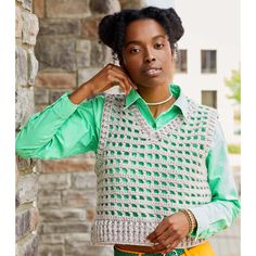 a woman in green shirt and yellow pants posing for the camera with her hand on her head