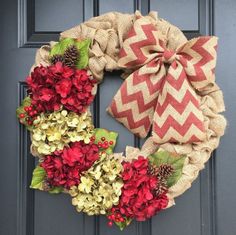 a wreath with red and yellow flowers is hanging on the front door's black door