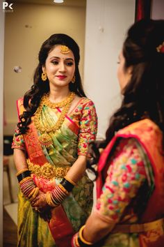 a woman in a colorful sari talking to another woman