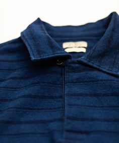 Introducing our Woodrow Indigo Stripe Polo, meticulously crafted for style and comfort. Made from 100% cotton and garment washed, this shirt boasts a timeless indigo stripe pattern. Featuring a unique, one-button placket, this polo has a rich finish that only gets better over time. 100% cotton indigo stripe jacquard Garment-washed One-button placket with corozo button Extended shirttail with side slits Signature flag tape on side seam Vintage inspired interior ID label Machine wash cold separate Blue Cotton Shirt With Horizontal Stripes, Striped Cotton Shirt With Placket, Everyday Cotton Shirt With Striped Collar, Blue Yarn-dyed Relaxed Fit Tops, Striped Yarn-dyed Cotton Shirt, Navy Cotton Top With Placket, Blue Yarn-dyed Tops With Relaxed Fit, Yarn-dyed Striped Cotton Shirt, Classic Indigo Collared Top