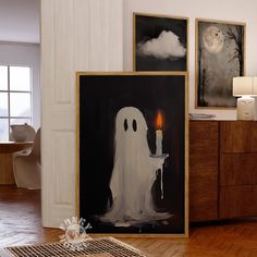 two paintings on the wall with one ghost holding a lit candle in front of it