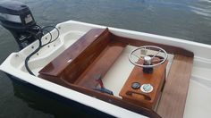 a small boat with a steering wheel on the water