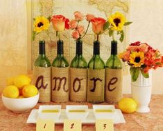 several bottles with flowers and lemons in them sitting on a table next to a map