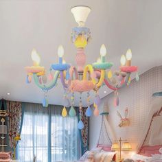 a chandelier hanging from the ceiling in a child's bedroom with pink bedding