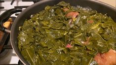 a pan filled with greens on top of a stove