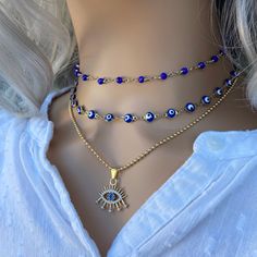 "These beautiful Blue evil eye choker gold are perfect to wear every day and protect yourself with positive energy. Talismans created to protect against the evil eye are also frequently called \"evil eyes\". '.'.'.'.'. * Chain 1: blue rosary chain gold plated. * Chain 2: made with evil eye beads on a gold plated chain enamel stainless steel. * Chain 3: ball chain with dainty evil eye charm cubic zircon. * Choose between this large variety of chains! * Fully finished with a matching 2 \"adjustabl Evil Eye Choker, Empath Protection, Hamsa Jewelry, Lucky Jewelry, Evil Eye Necklace Gold, Choker Gold, Raw Crystal Necklace, Layered Necklace Set, Wear Necklaces