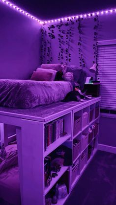 a bedroom with purple lights on the ceiling and bookshelves in front of it