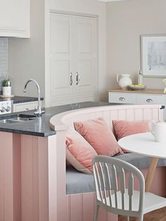 a kitchen with pink and white decor in it's center island next to a dining room table