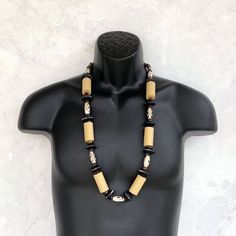 This long African style necklace was hand beaded using an amazing mix of beads - distressed black wood rondelles, cylindrical beige wooden beads, black and white African gemstones, a variety of small brown wood beads, dalmatian gemstones, and more! The necklace measures a little over 35 inches in length and is securely fastened with a sterling silver toggle clasp. Perfect for any gender and a one of kind piece! Perfect for today's bohemian looks! Length can be adjusted if needed - just ask! Wood Black Necklaces With Wooden Beads, Unique Black Necklaces With Wooden Beads, Black Beaded Heishi Beads Necklace, Black Wooden Beads For Jewelry Making, Artisan Black Beaded Hand-strung Necklace, Black Wooden Beads Necklace For Jewelry Making, Black Heishi Beaded Necklaces, Black Heishi Beads Necklace For Gift, Handmade Black Heishi Beads