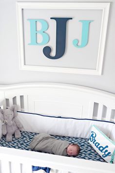 a baby is laying in his crib with the name jj on it's wall