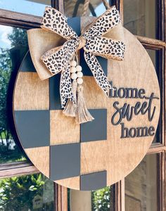 a wooden sign that says home sweet home with a cheetah bow on it