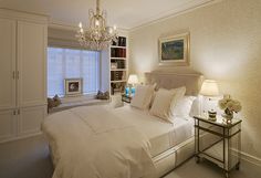 a bedroom with a chandelier hanging from the ceiling next to a bed in front of a window