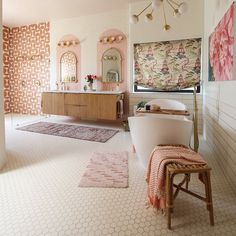 a bathroom with pink and white decor on the walls, rugs and bathtub