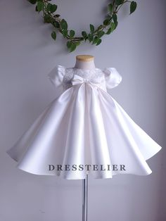 << Off-white mikado pleated dress >> This dress is made of high quality mikado and beaded lace. Hand sewn beaded lace applique on the bodice and on the back bow.   It has soft crinoline inside of the skirt.  Fully lined with 100% cotton lining. Back zipper.  Bows are included in this order. For sizing, please check the size chart.  Designed and handmade by me in my studio.  Please follow @Dresstelier DM me if you have any questions. Thank you! Cream Princess Dress For Summer Wedding, Fitted Princess Dress For Summer Wedding, Short Sleeve Organza Dress With Fitted Bodice, Elegant Ruffled Baptism Dress For Party, Elegant Baptism Dress With Lace Bodice, Elegant Fitted Baptism Dress With Lace Bodice, Summer Wedding Fitted Princess Dress, Fitted Princess Style Baptism Dress For Party, Fitted Short Sleeve Princess Dress For Wedding