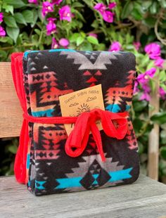 a small pouch with a red ribbon tied around it on top of a wooden bench