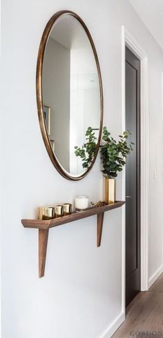 an iphone photo of a hallway with white walls and wood flooring on the phone