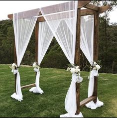 an outdoor wedding setup with white drapes and flowers