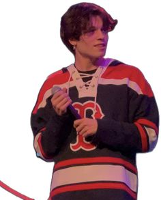 a young man holding a microphone and wearing a striped shirt with the boston red sox on it