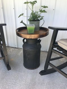 a potted plant sitting on top of a wooden table next to two stools