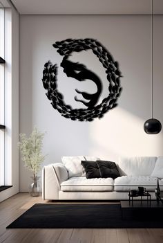 a living room with a white couch and black dragon wall decal