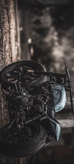 a black motorcycle is parked in front of a wall with chains hanging from it's sides