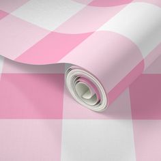 a pink and white checkered wallpaper with a roll of paper on top of it