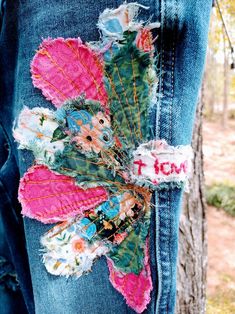 the jeans are decorated with flowers and leaves