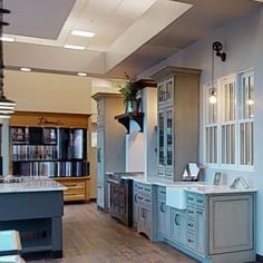 a large kitchen with blue cabinets and white counter tops