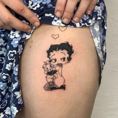 a woman's thigh with a tattoo of a girl holding a baby on it