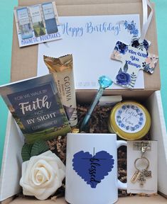 a gift box filled with personal items including a coffee mug, keychain and book