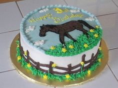 a birthday cake with a horse on the top and green grass around it, sitting on a tile floor